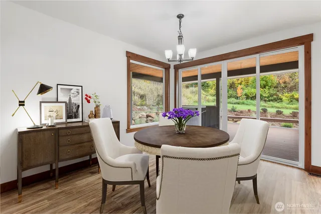 a dining room with furniture a chandelier and wooden floor