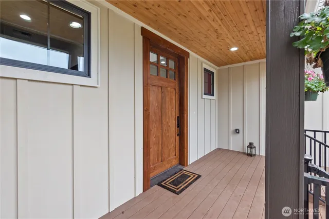a view of a hallway with wooden floor and a potted plant