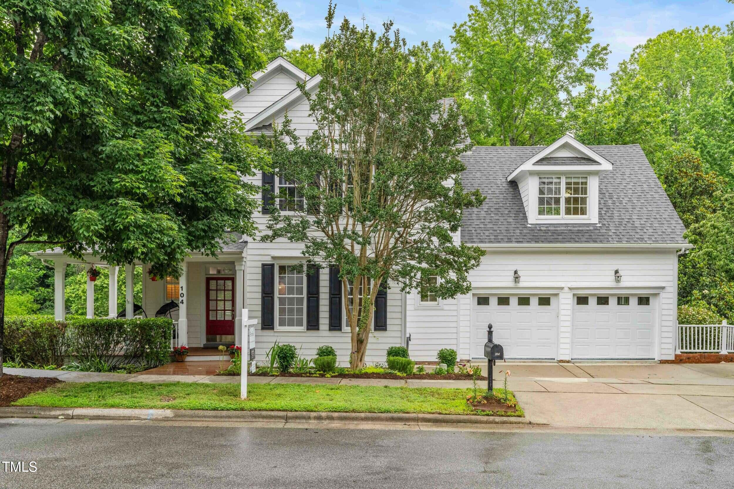 104 Edgewater Circle Chapel Hill, NC 27516 - Photo 2 of 4 a front view of a house with a yard and garage