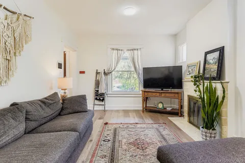 a living room with furniture kitchen view and a large window