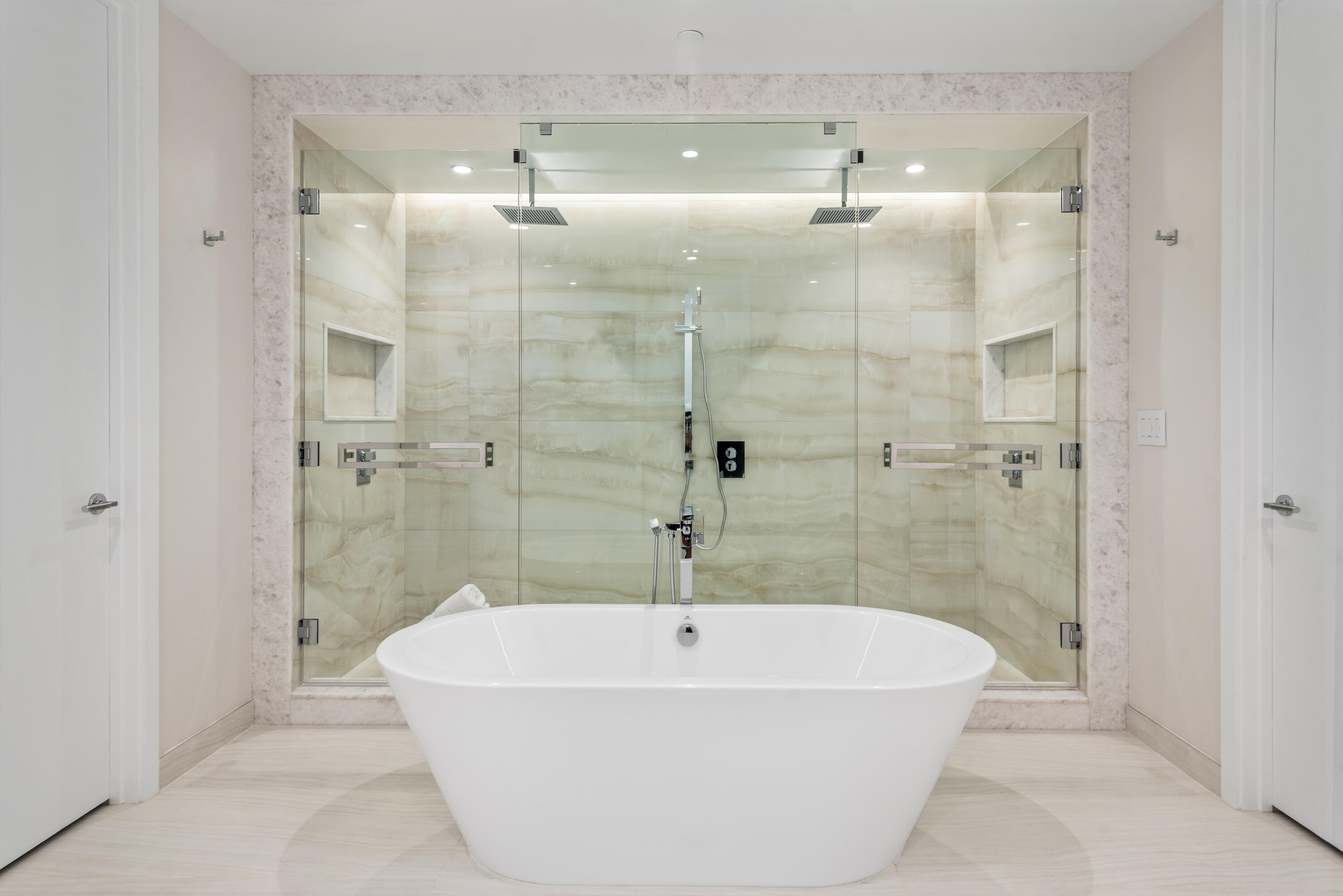 210 Southeast Mizner Boulevard, Unit 604 Boca Raton, FL 33432 - Photo 11 of 19 a white bath tub sitting in a bathroom and a shower