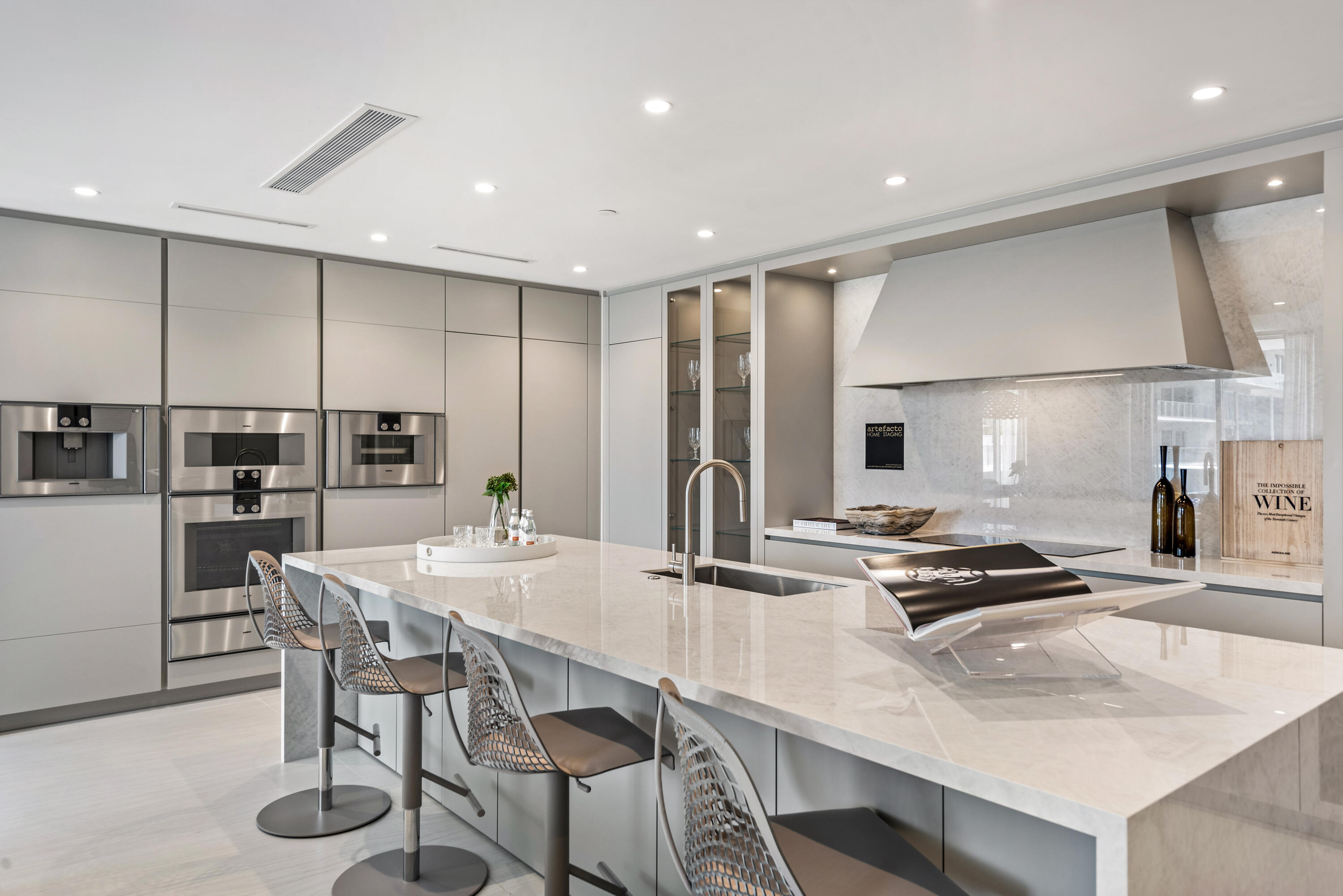 210 Southeast Mizner Boulevard, Unit 604 Boca Raton, FL 33432 - Photo 5 of 19 a kitchen with kitchen island a stove a table and chairs in it