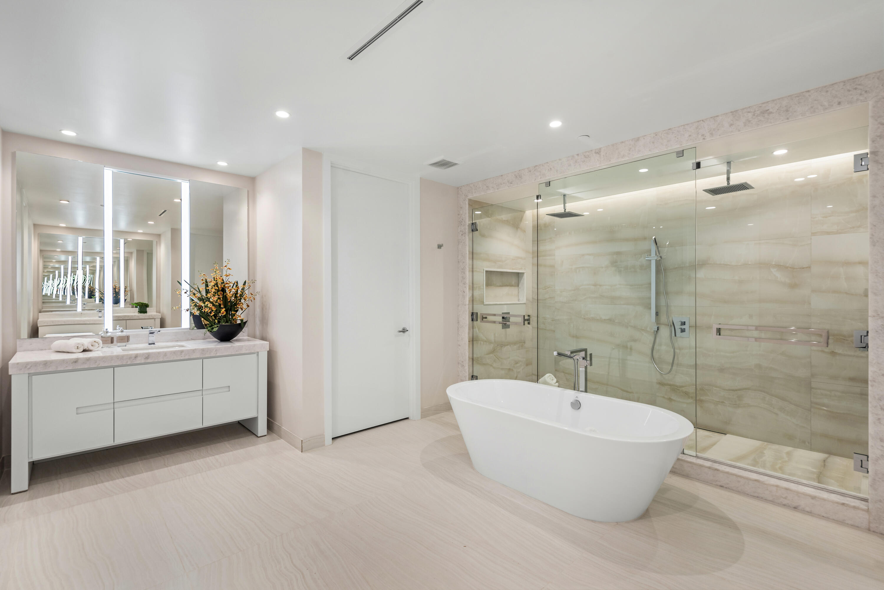 210 Southeast Mizner Boulevard, Unit 604 Boca Raton, FL 33432 - Photo 10 of 19 a bathroom with a bathtub and a double vanity sink a mirror