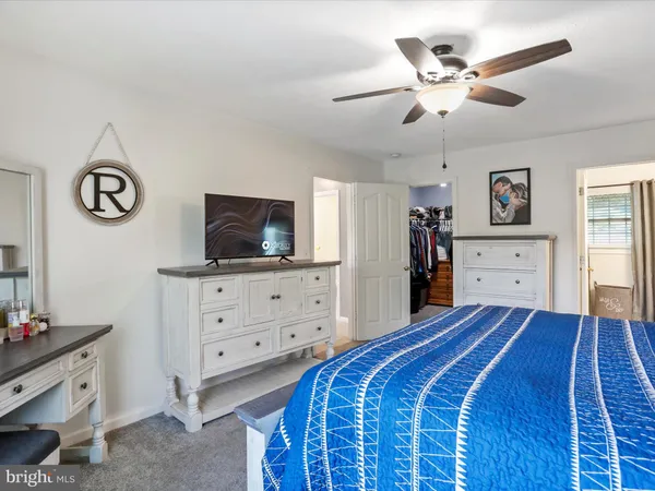 a bedroom with a large bed and a ceiling fan