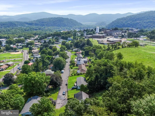 an aerial view of a house with swimming pool and large trees