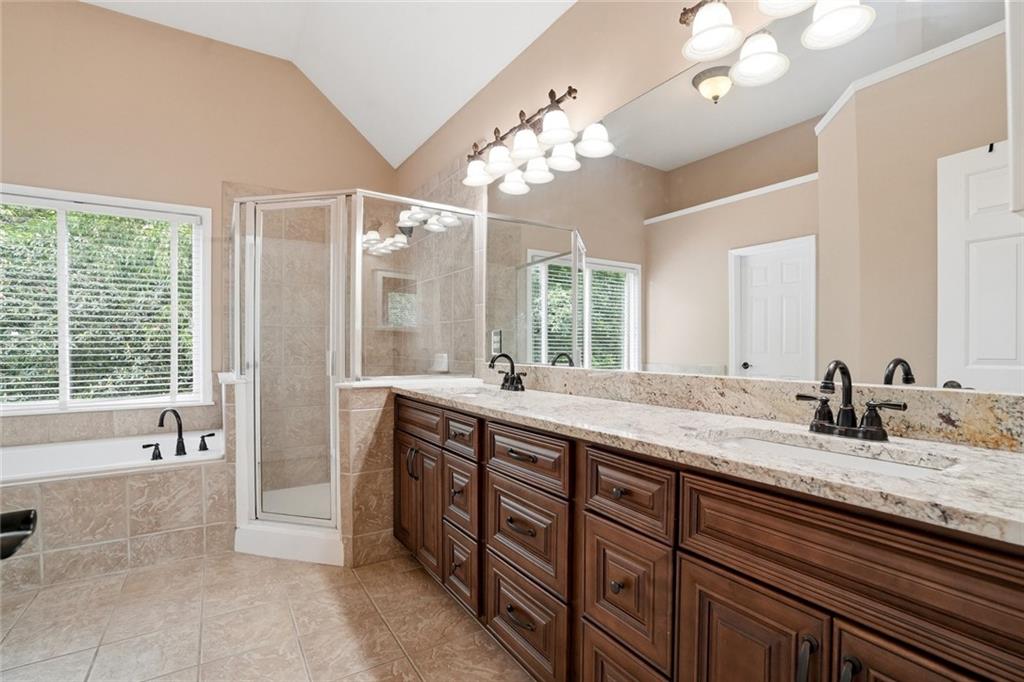 855 Freedom Way Cumming, GA 30040 - Photo 14 of 25 a spacious bathroom with a granite countertop sink a large mirror and a bathtub