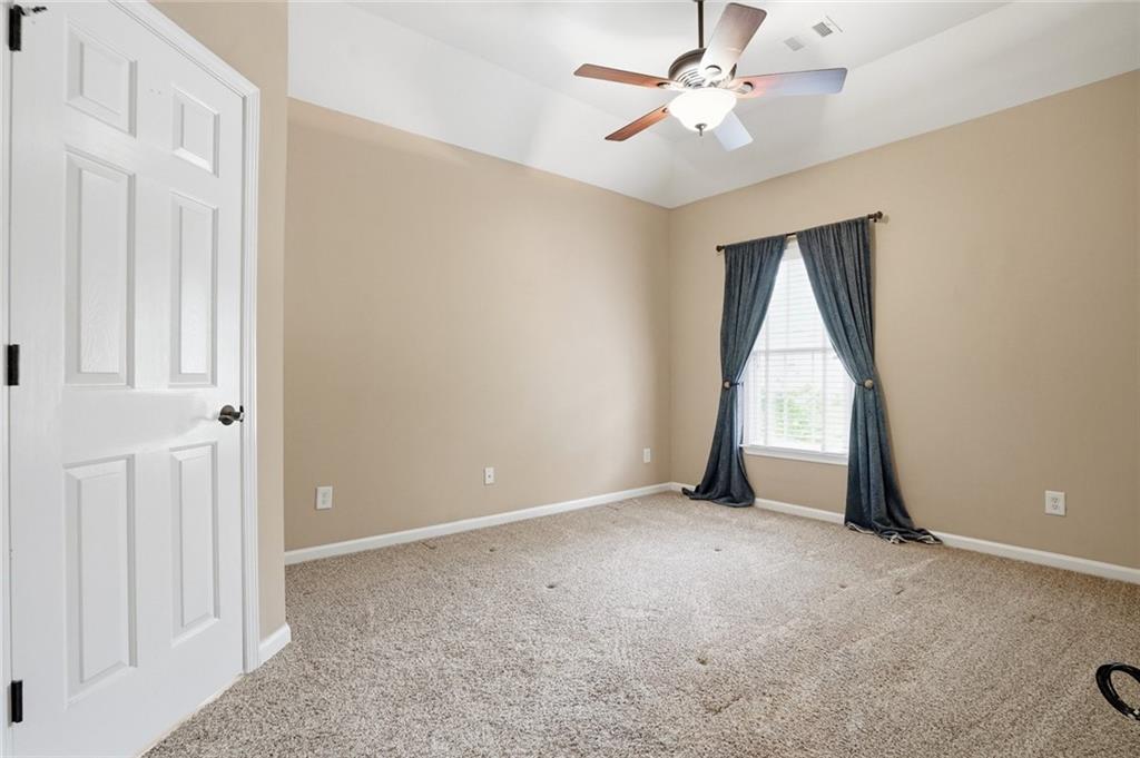 855 Freedom Way Cumming, GA 30040 - Photo 17 of 25 an empty room with a ceiling fan and a window