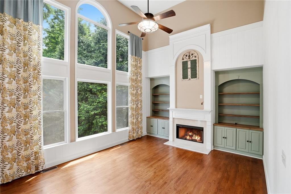 855 Freedom Way Cumming, GA 30040 - Photo 10 of 25 a view of a livingroom with a fireplace a ceiling fan and windows