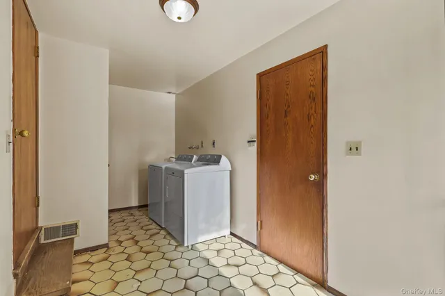 a view of an empty room with wooden floor and stairs