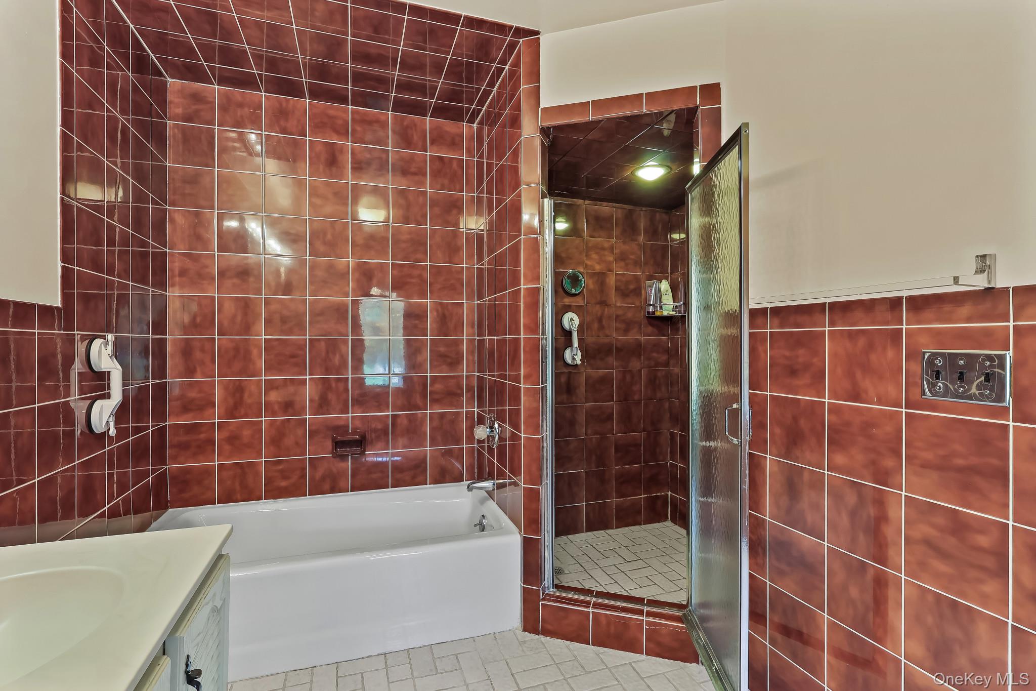 37 Century Trail Harrison, NY 10528 - Photo 22 of 43 Bathroom featuring tile walls, a garden tub, a shower stall, tile patterned floors, and vanity