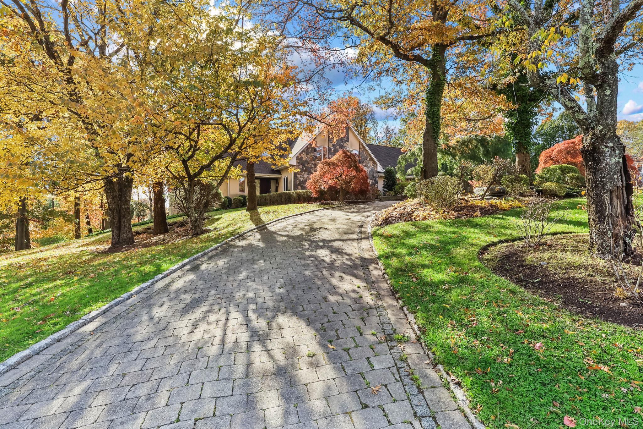 37 Century Trail Harrison, NY 10528 - Photo 3 of 43 View of property hidden behind natural elements featuring a front lawn and decorative driveway