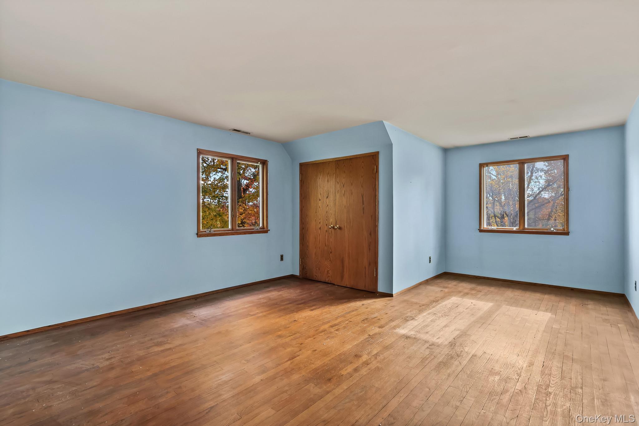 37 Century Trail Harrison, NY 10528 - Photo 31 of 43 Bedroom featuring hardwood / wood-style flooring, a closet, and multiple windows