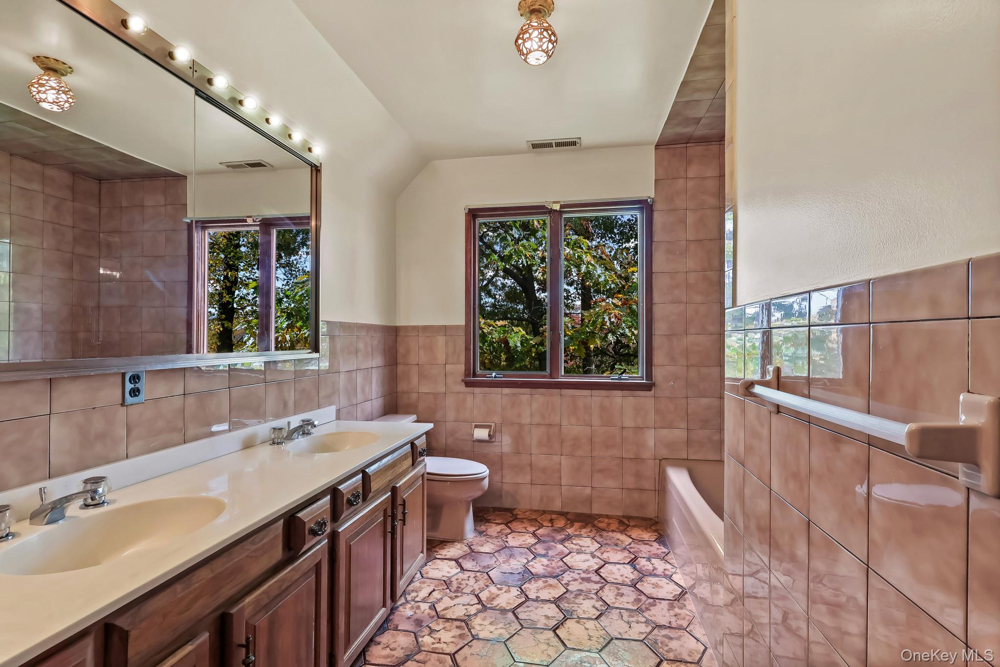 37 Century Trail Harrison, NY 10528 - Photo 32 of 43 Hall Bathroom with tile walls, healthy amount of natural light, double vanity, a tub, and wainscoting