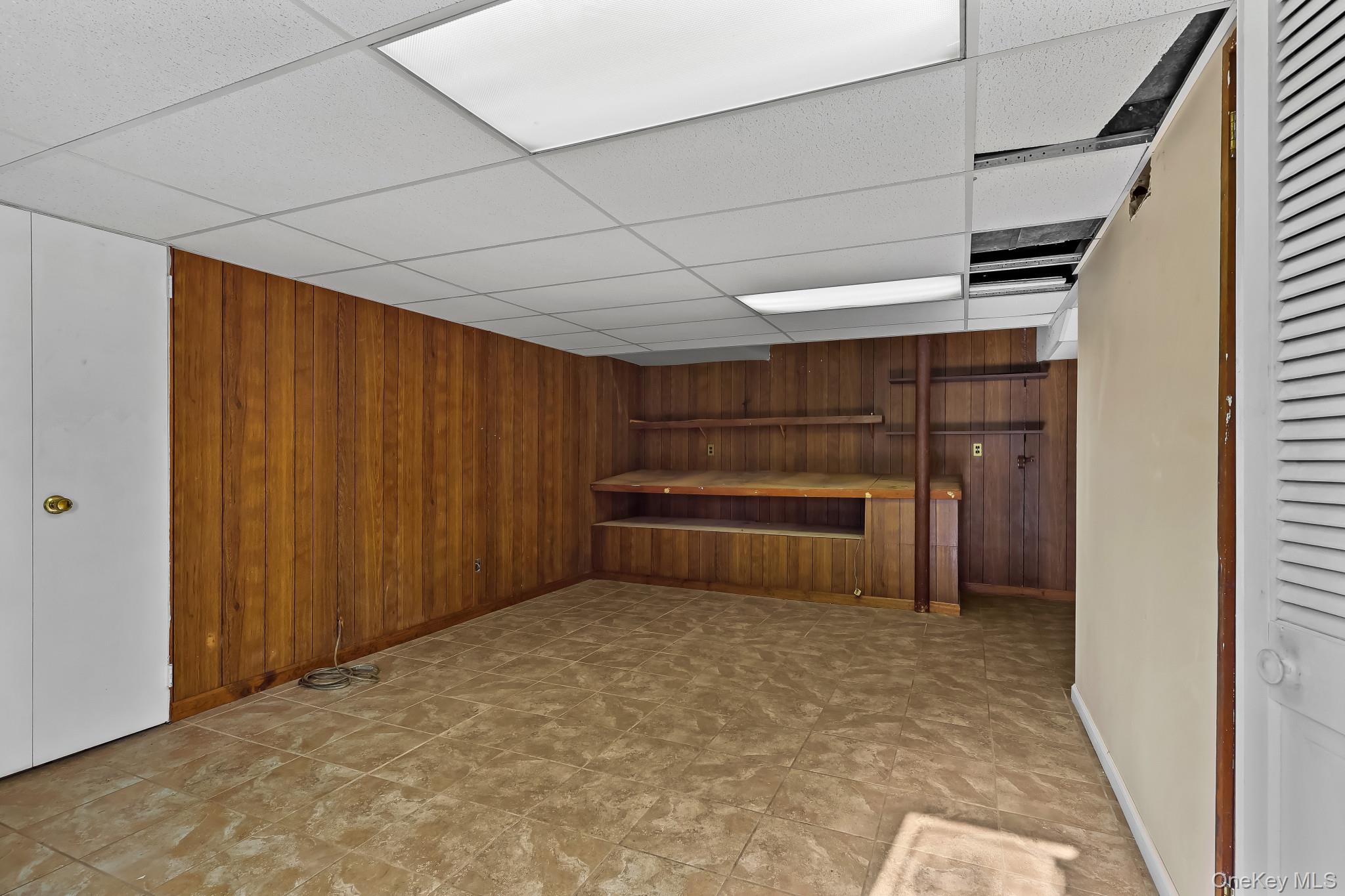 37 Century Trail Harrison, NY 10528 - Photo 35 of 43 Finished basement featuring wood walls and a drop ceiling