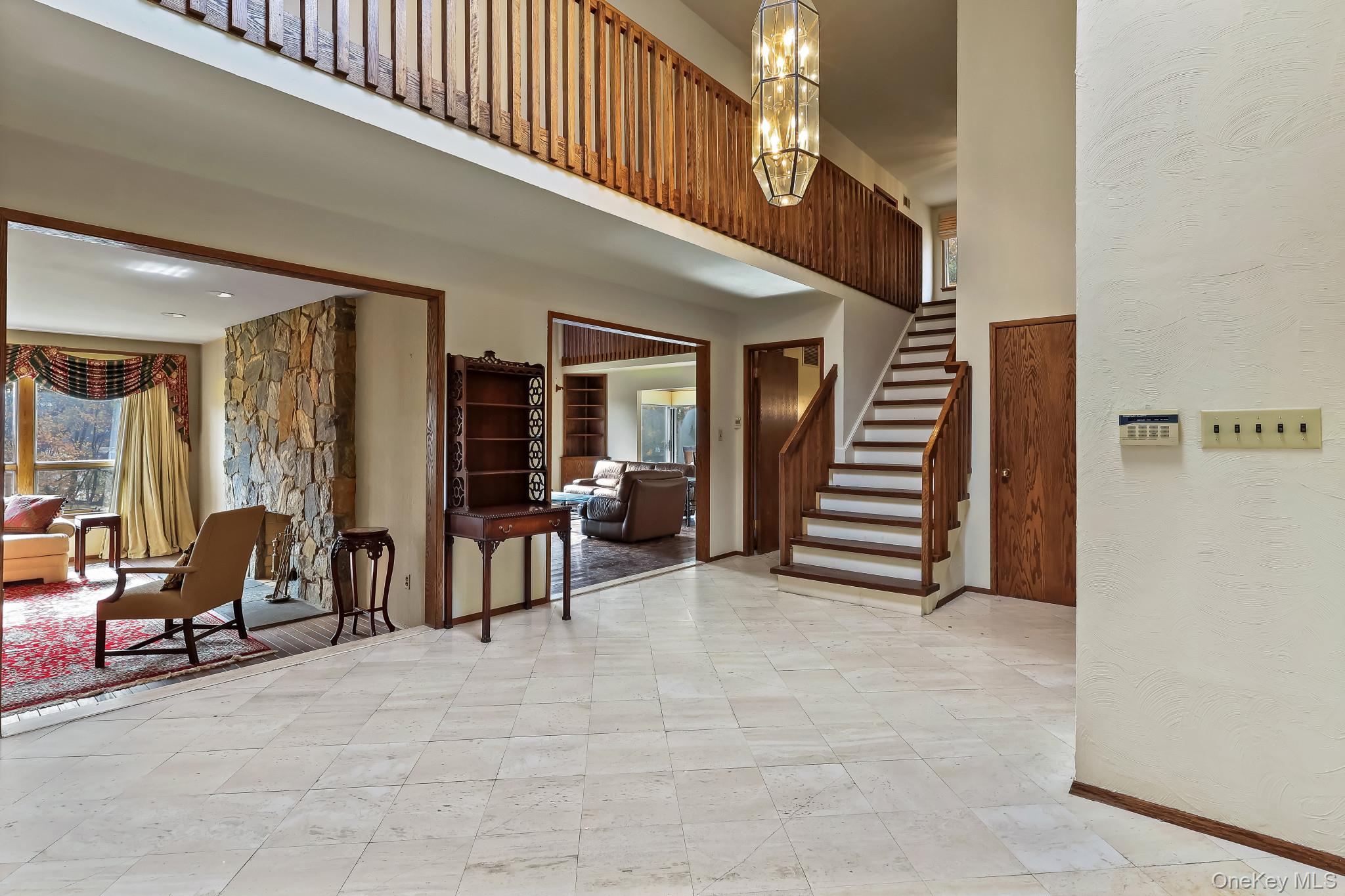 37 Century Trail Harrison, NY 10528 - Photo 6 of 43 Entrance foyer with stairs, a textured wall, a high ceiling, and a chandelier