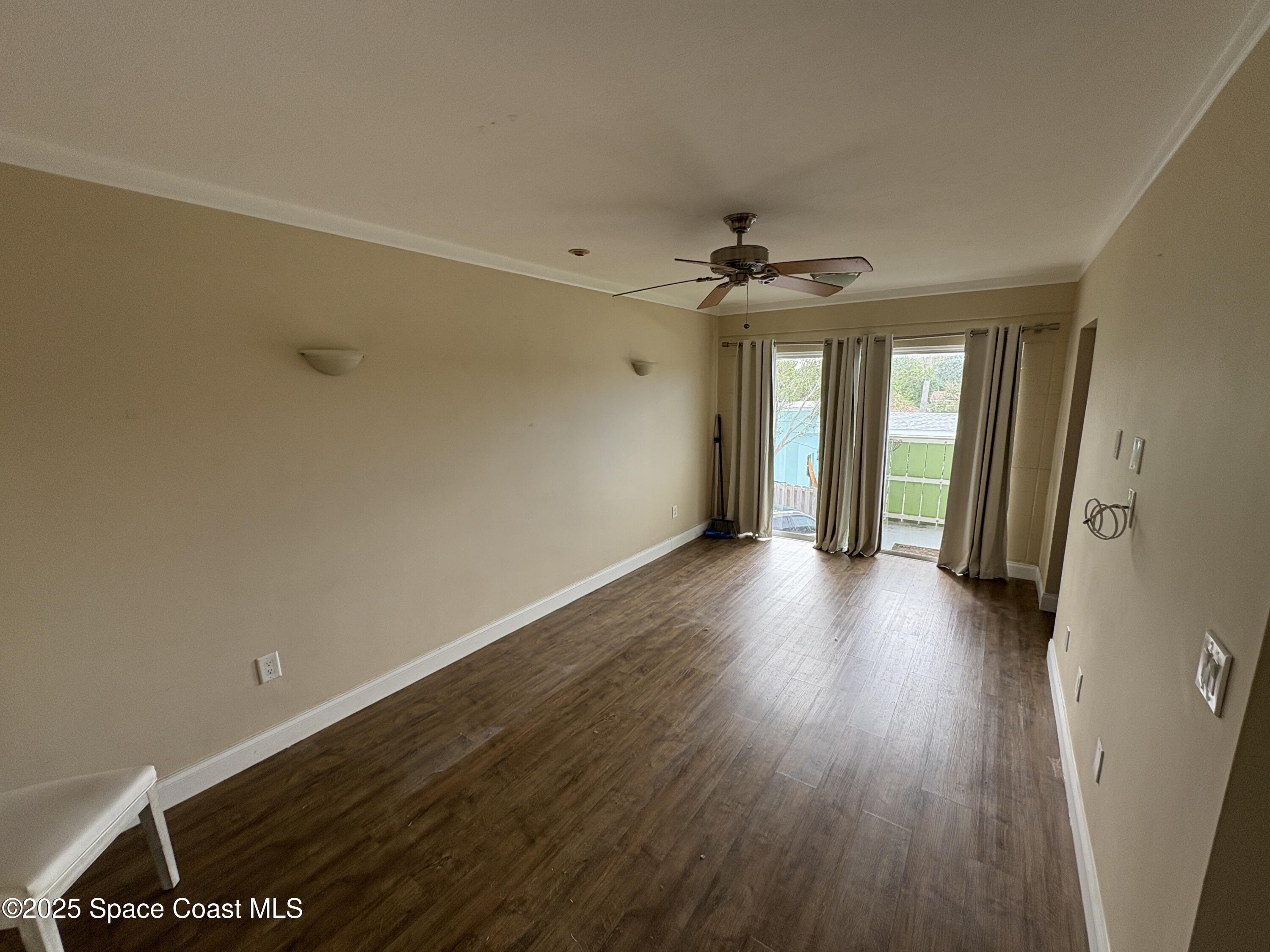 801 South Brevard Avenue, Unit K Cocoa Beach, FL 32931 - Photo 3 of 14 a view of a room with wooden floor and ceiling fan