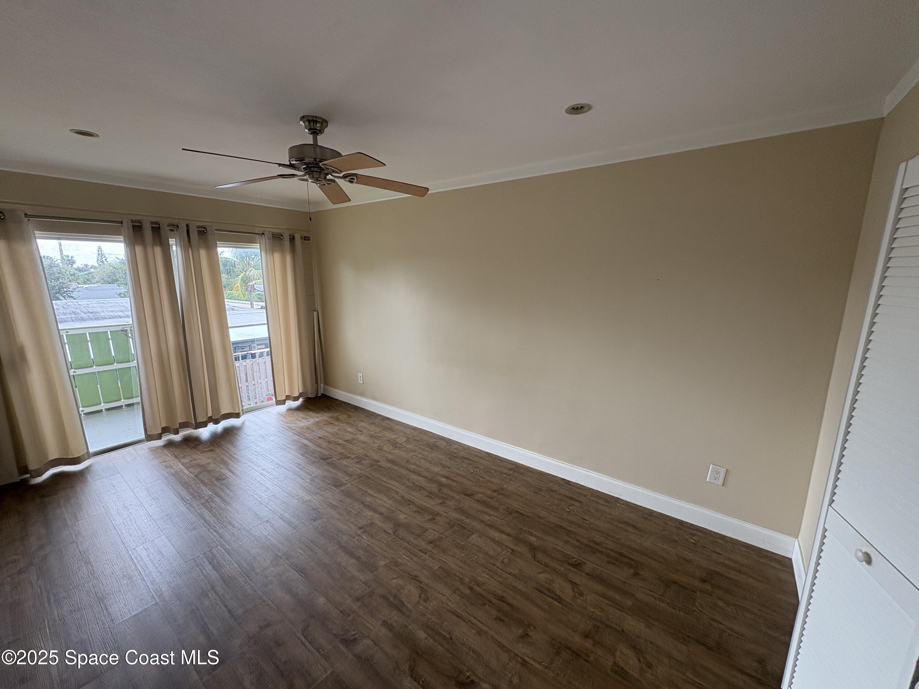 801 South Brevard Avenue, Unit K Cocoa Beach, FL 32931 - Photo 6 of 14 an empty room with wooden floor and windows