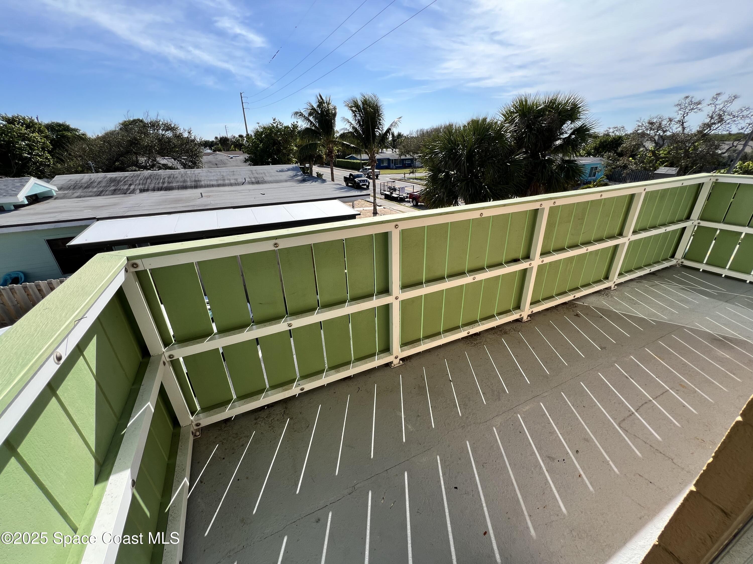 801 South Brevard Avenue, Unit K Cocoa Beach, FL 32931 - Photo 8 of 14 a view of a balcony with wooden floor and fence