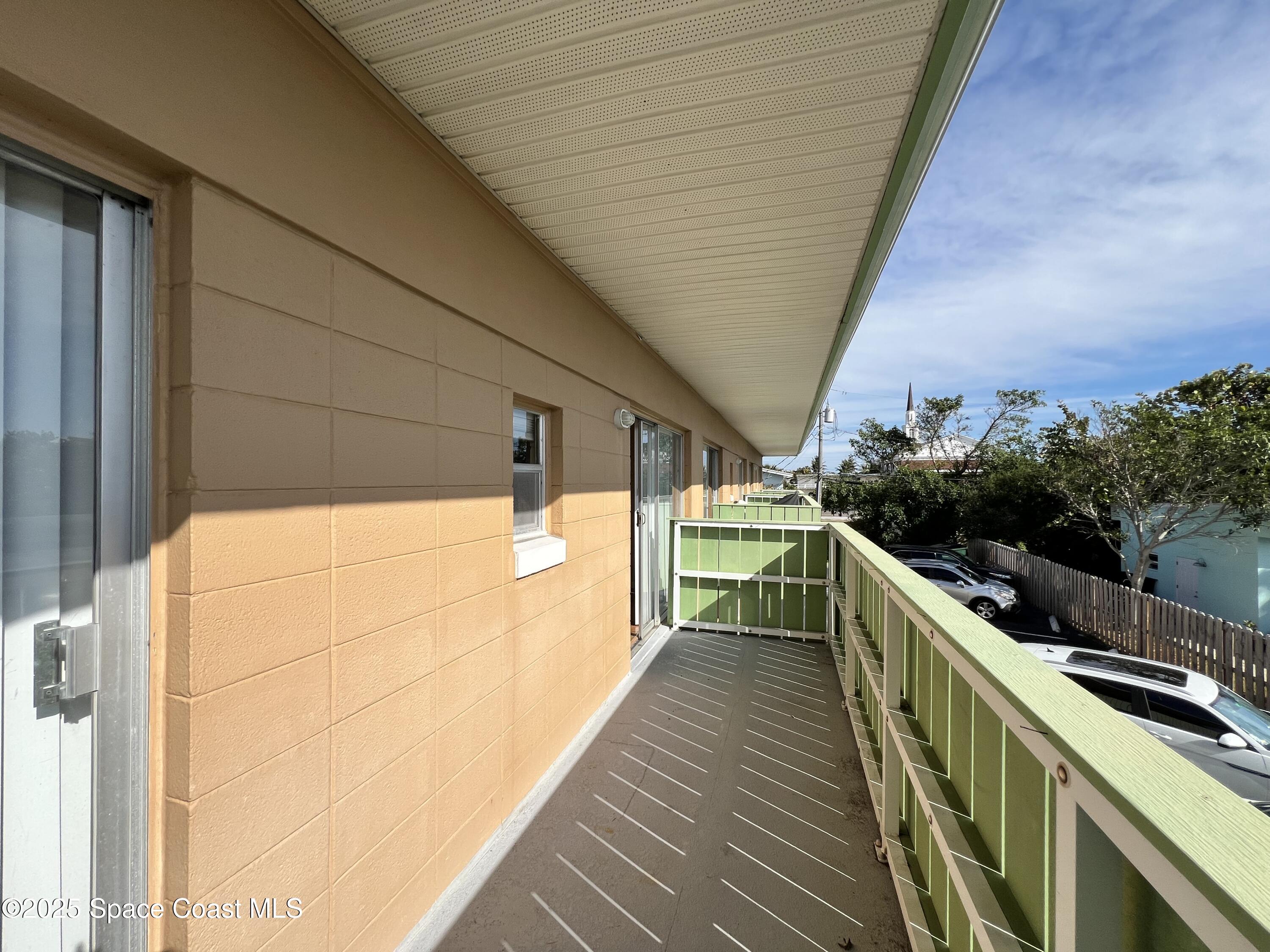 801 South Brevard Avenue, Unit K Cocoa Beach, FL 32931 - Photo 9 of 14 a view of balcony with wooden floor and fence
