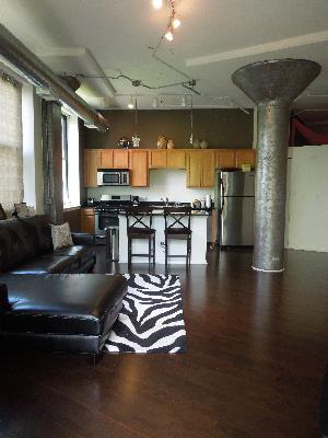 2323 West Pershing Road, Unit 226 Chicago, IL 60609 - Photo 4 of 8 a living room with furniture a large window and kitchen view