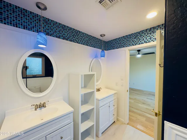 a bathroom with a double vanity sink mirror and shower