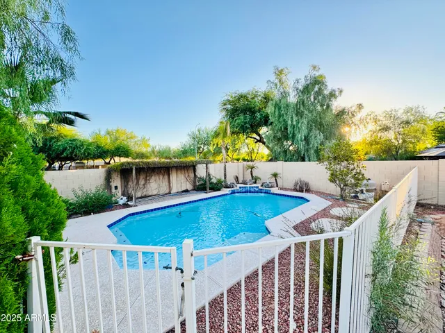 a view of a swimming pool with a patio and a yard