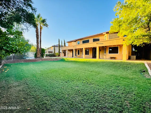 a view of a house with a big yard and large trees