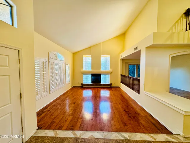a living room with wooden floor and a fireplace
