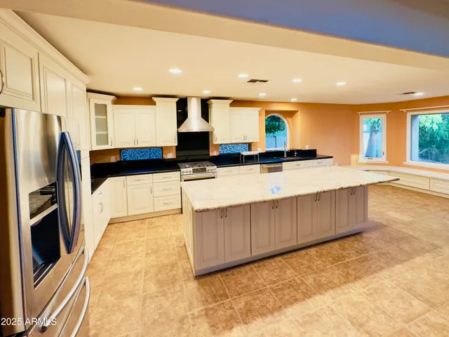 a kitchen with stainless steel appliances granite countertop a sink and a refrigerator