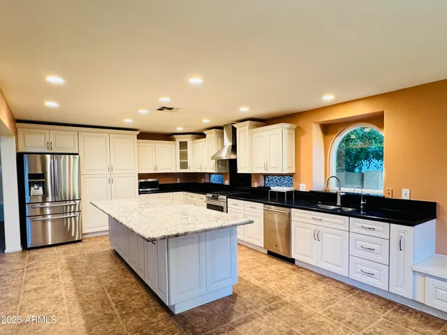 a large kitchen with stainless steel appliances granite countertop a large counter top and a stove