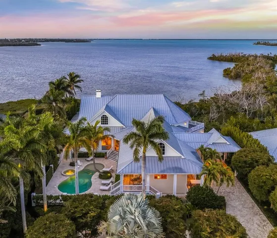 an aerial view of a house with a yard and lake view