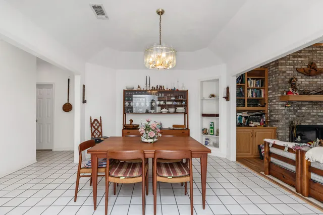 a view of a dining room with furniture a chandelier and wooden floor