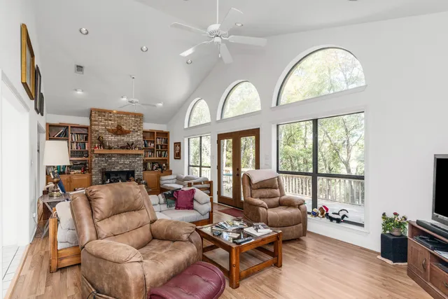 a living room with furniture a fireplace and a large window