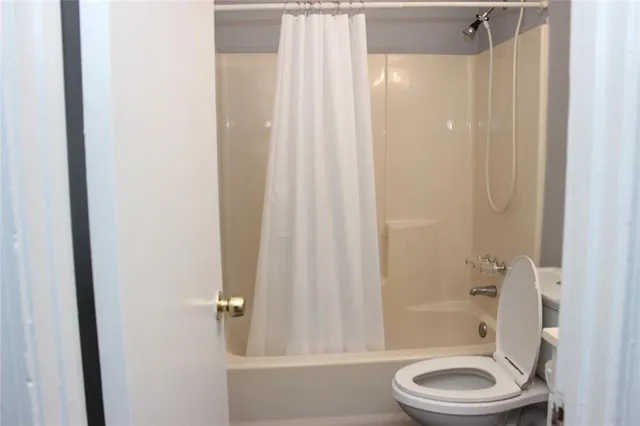 a bathroom with a granite countertop bathtub shower and toilet