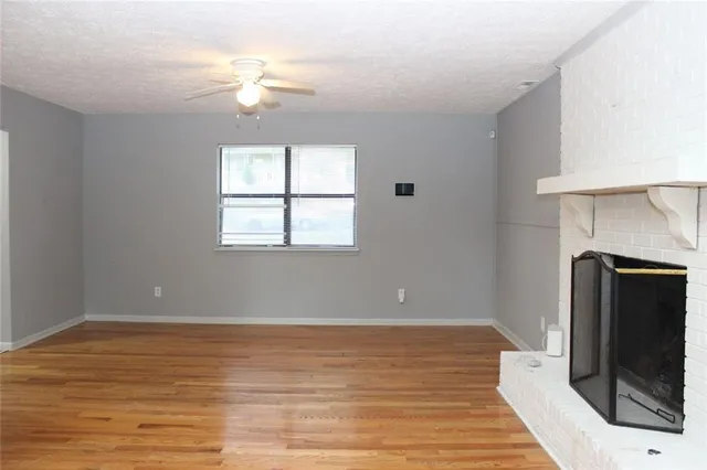 wooden floor fireplace and windows in an empty room