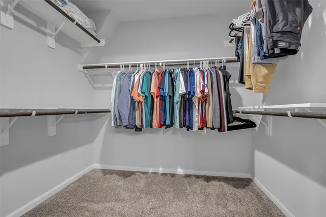 a view of walk in closet with clothes
