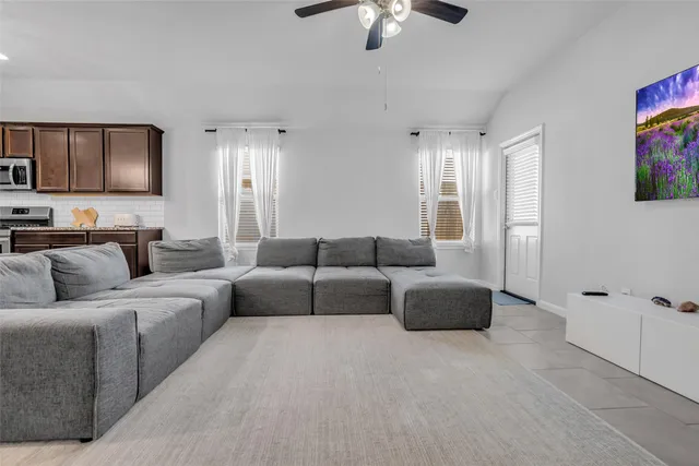 a living room with furniture ceiling fan and a window