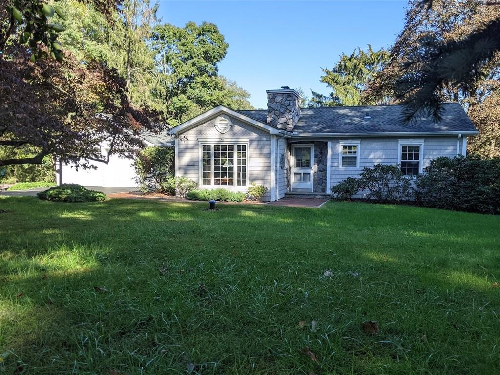 a front view of a house with a garden and trees