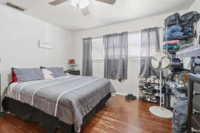 a bedroom with bed and wooden floor