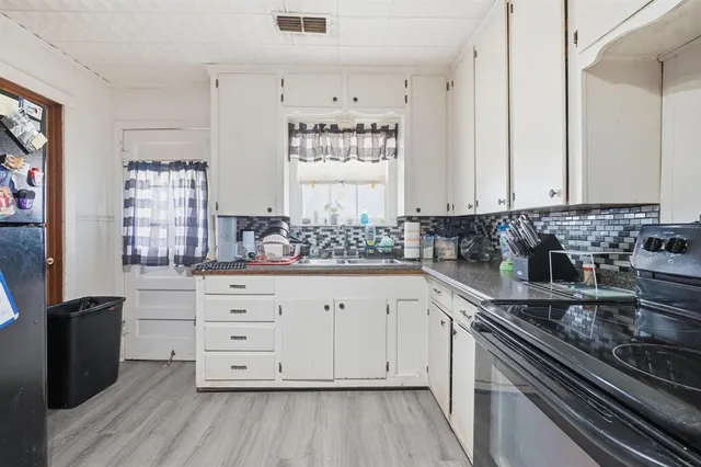 a kitchen with granite countertop white cabinets and white appliances