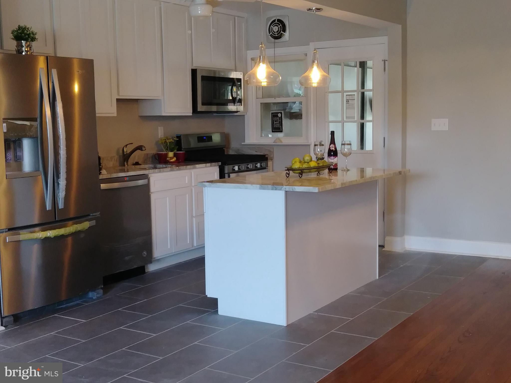 3812 Ednor Road Baltimore, MD 21218 - Photo 4 of 22 a kitchen with stainless steel appliances a refrigerator sink and white cabinets