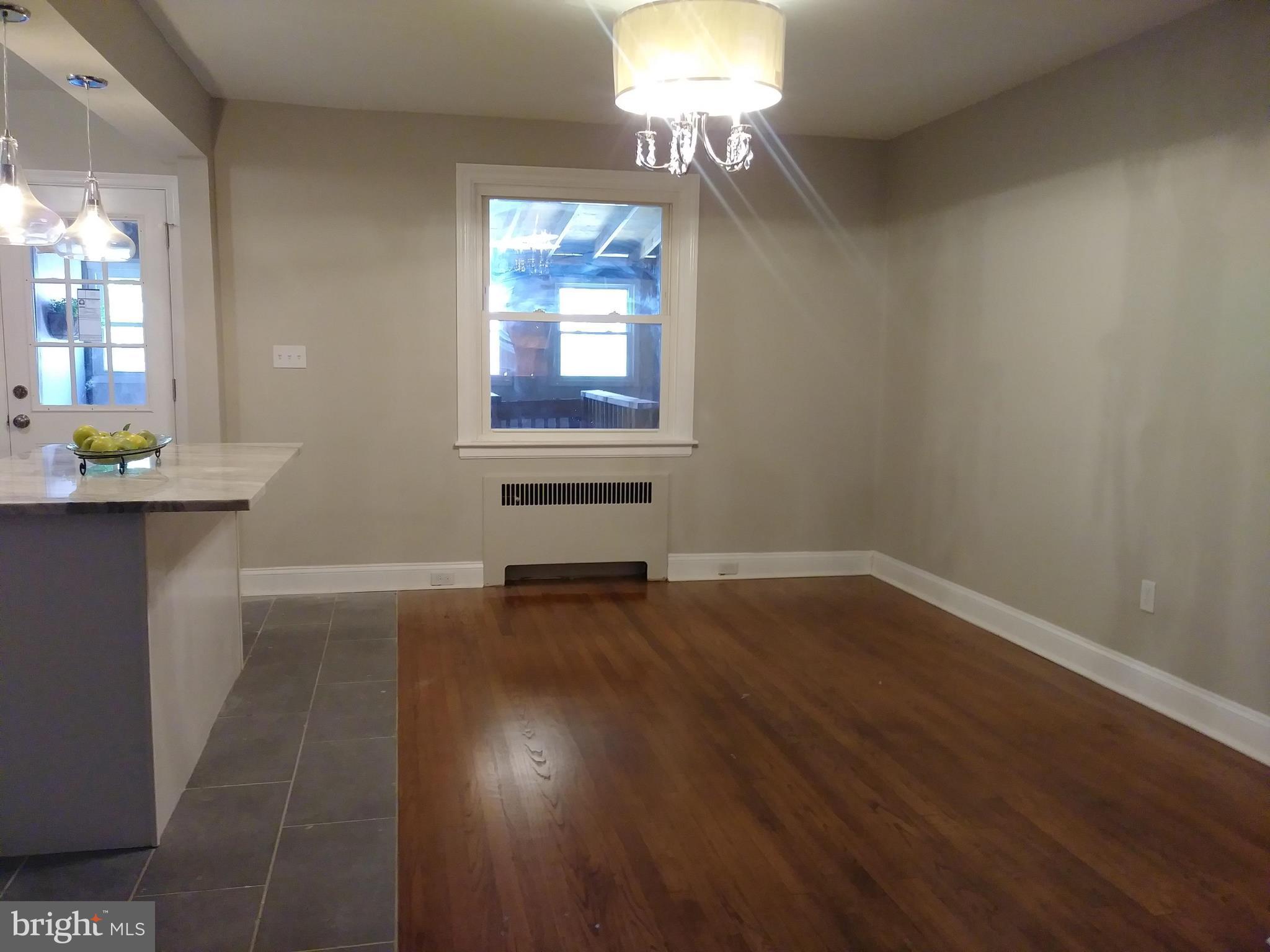 3812 Ednor Road Baltimore, MD 21218 - Photo 5 of 22 an empty room with a wooden floor and a window