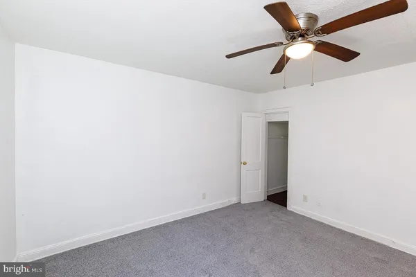 an empty room with a ceiling fan and a fan