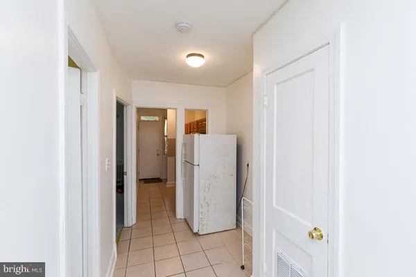 a view of a storage & utility room with refrigerator