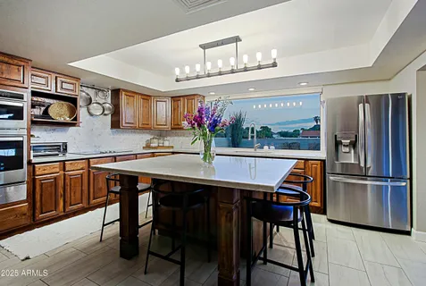 a dining room with stainless steel appliances a table and chairs