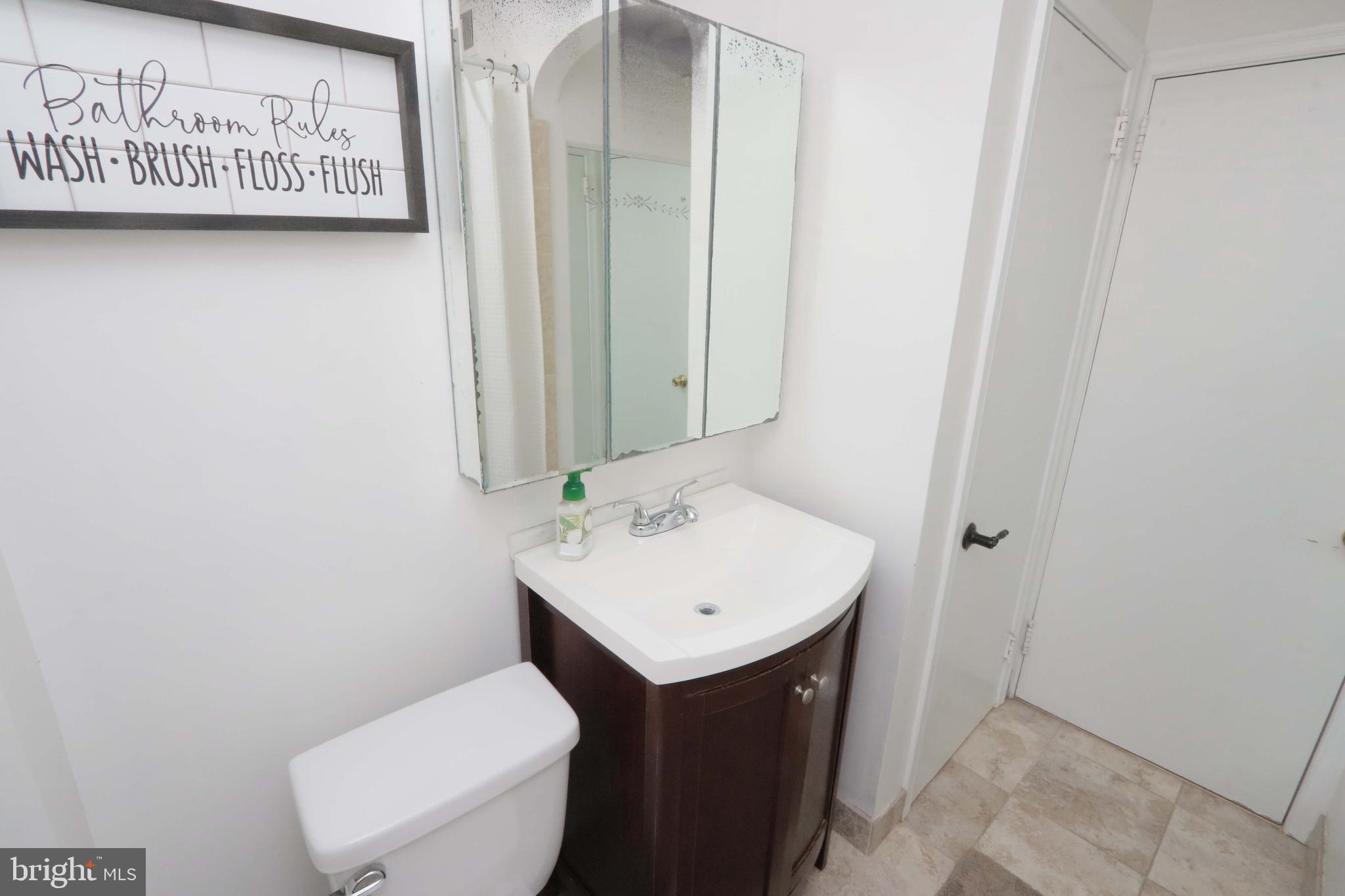 8134 Revere Street Philadelphia, PA 19152 - Photo 36 of 49 a bathroom with a toilet sink and mirror