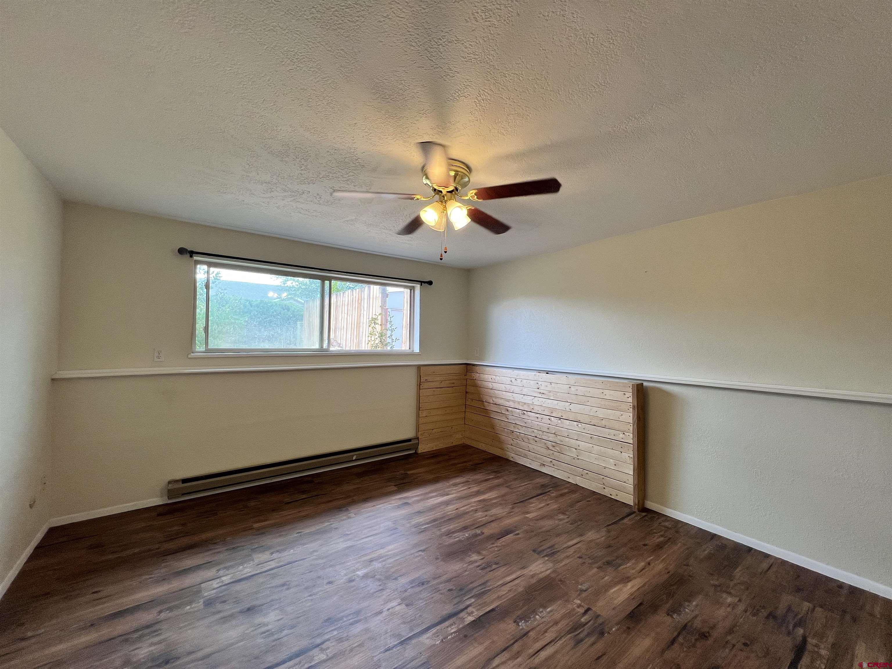 1328 Jackson Street Cortez, CO 81321 - Photo 28 of 37 an empty room with wooden floor and windows