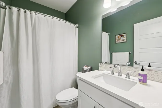 a bathroom with a sink a toilet and a mirror