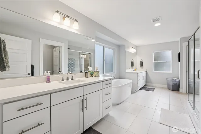 a spacious bathroom with a double vanity sink toilet mirror and window