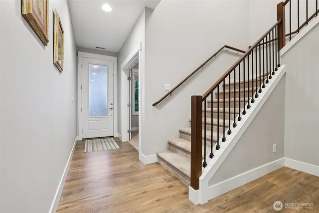 a view of a hallway with wooden floor and entryway